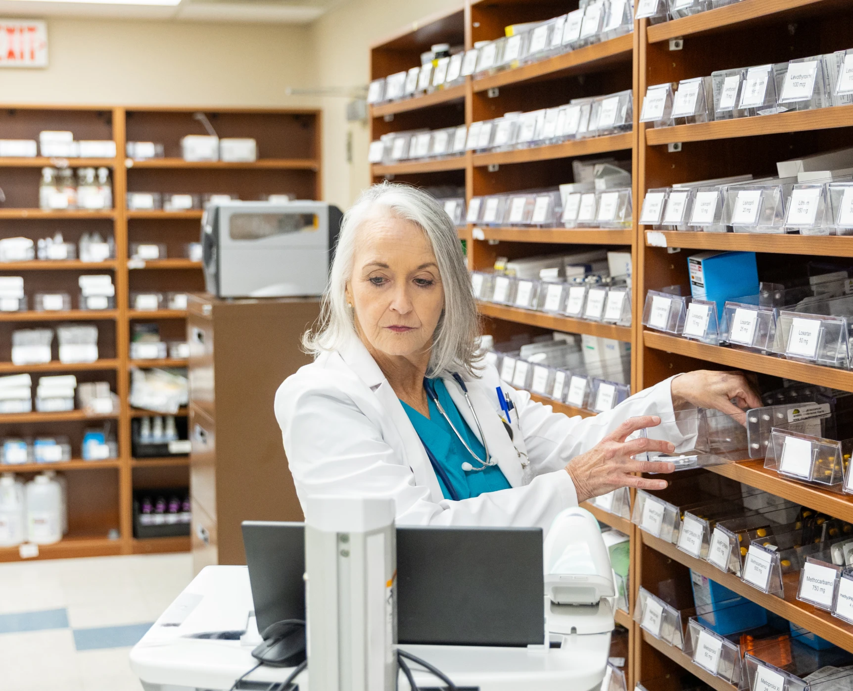 Pharmacist organizing medication shelves